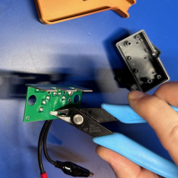 Flush cutters cutting a zip tie on the
PCB